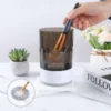 Hands-on use of electric makeup brush cleaner showing brush insertion and effective deep cleansing in water.