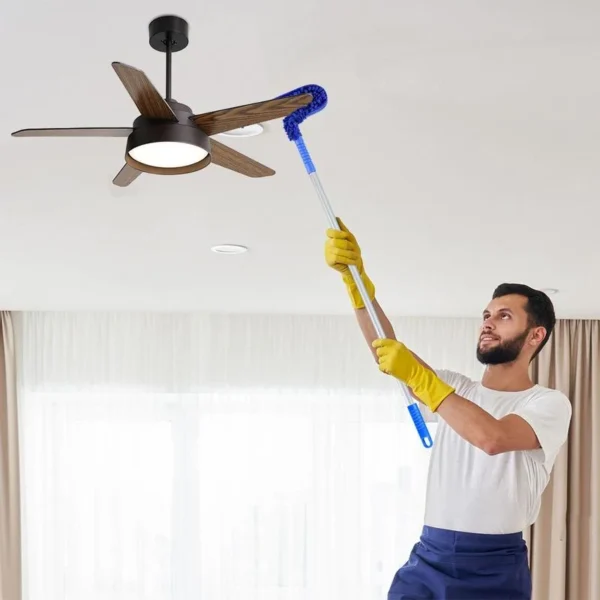 Man cleaning ceiling fan blades with flexible microfiber duster and telescopic handle