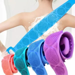 Woman using silicone body scrubber belt to exfoliate back with colorful scrubbers in foreground
