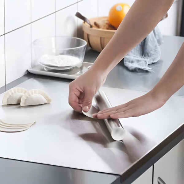 Rolling dumpling dough with rolling pin on the board