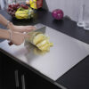 Chopping cabbage with a cleaver on stainless steel cutting board in modern kitchen