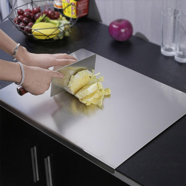 Chopping cabbage with a cleaver on stainless steel cutting board in modern kitchen